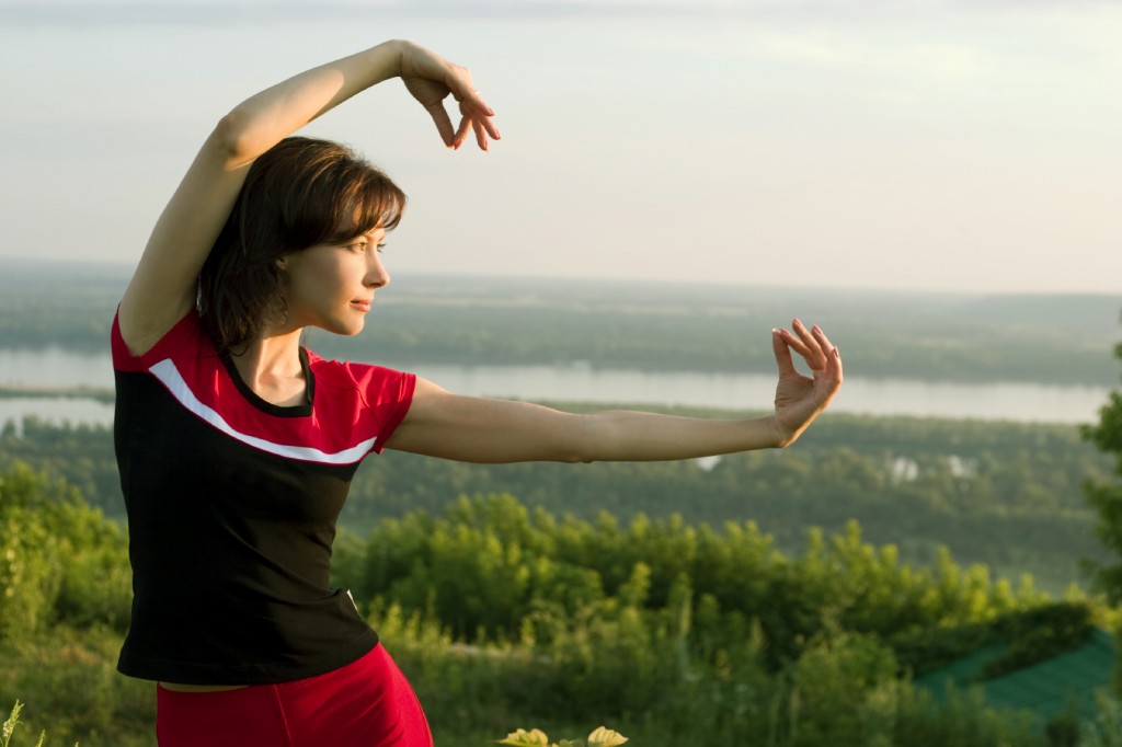 young beautiful girl doing some exercises in the meadow